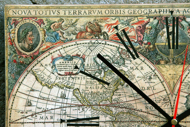 Zegar na desce ze starą mapą świata