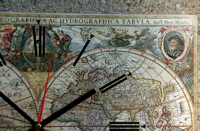Zegar na desce ze starą mapą świata