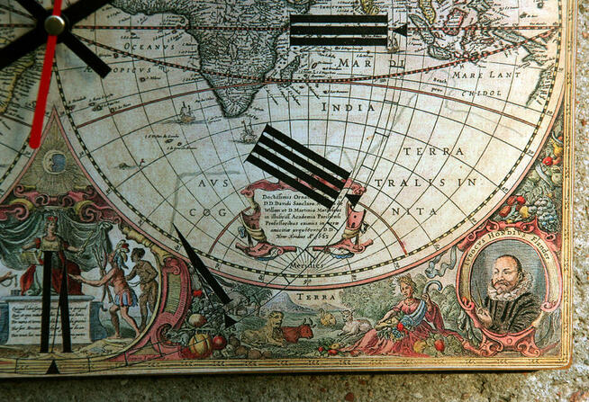 Zegar na desce ze starą mapą świata