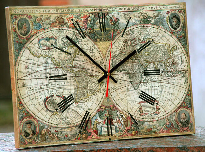 Zegar na desce ze starą mapą świata