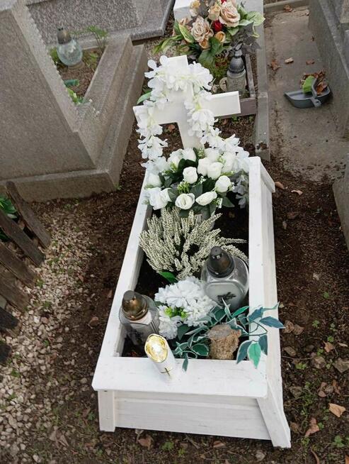 Tymczasowa obudowa nagrobka dla dziecka z krzyżem.