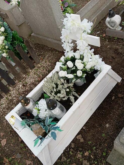 Tymczasowa obudowa nagrobka dla dziecka z krzyżem.