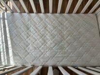 drewniane białe łóżeczko z materacem