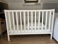 drewniane białe łóżeczko z materacem