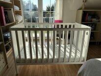 drewniane białe łóżeczko z materacem