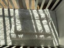 drewniane białe łóżeczko z materacem