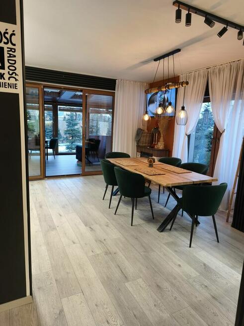 Dom szczytowy z ogrodem zimowym i garażem.