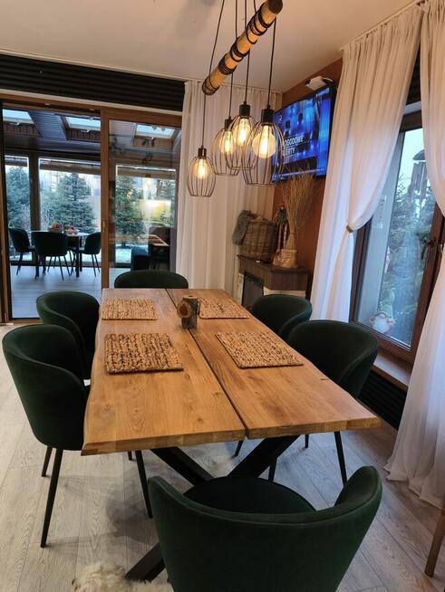 Dom szczytowy z ogrodem zimowym i garażem.