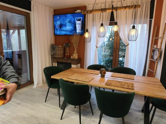 Dom szczytowy z ogrodem zimowym i garażem.