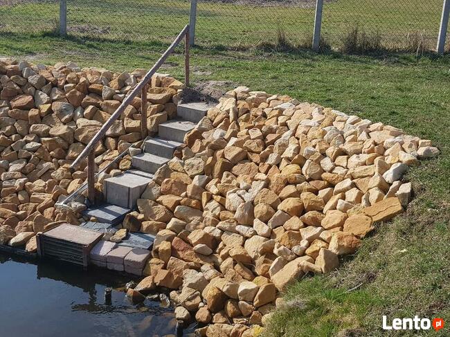 Kamień na skarpy brzegu stawu jeziora zbiornika wodnego