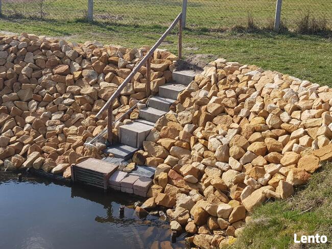 Kamień na skarpy brzegu stawu jeziora zbiornika wodnego