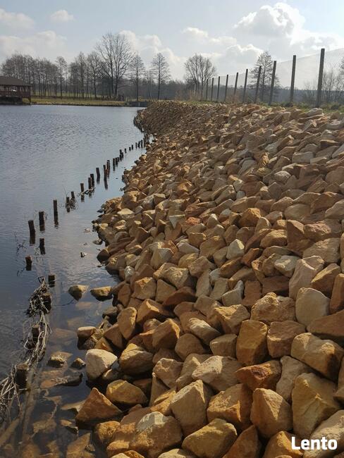 Kamień na skarpy brzegu stawu jeziora zbiornika wodnego