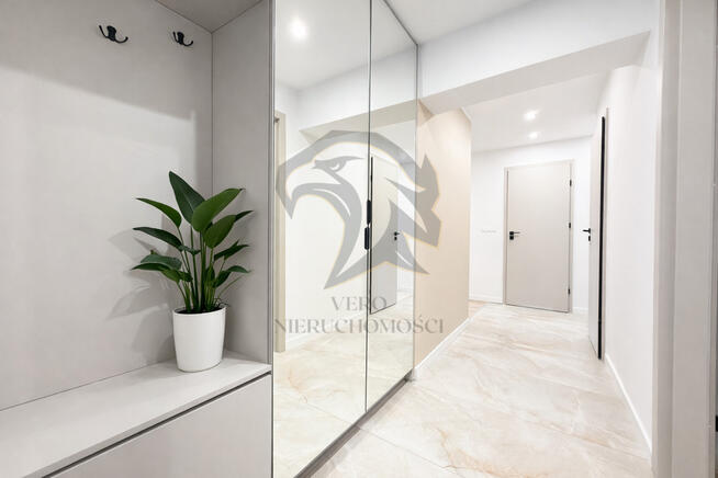 Wiesia w fartuchu w kratę stoi z wałkiem w ręku.