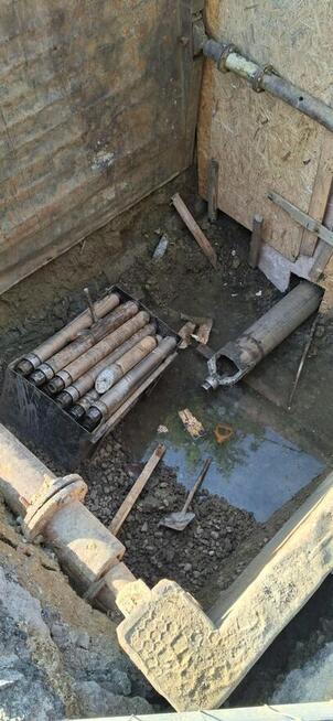 Monter sieci sanitarnych zewnątrznych i operator koparki