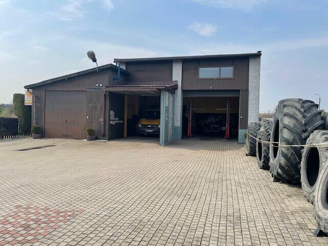 Dom z warsztatem serwisu ogumienia i basenem .