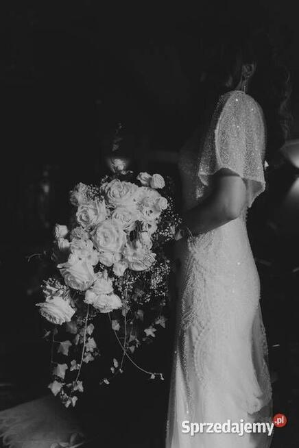 Piękna suknia ślubna z trenem, bogato zdobiona.