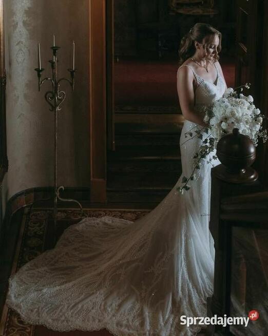 Piękna suknia ślubna z trenem, bogato zdobiona.