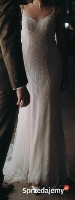 Piękna suknia ślubna z trenem, bogato zdobiona.