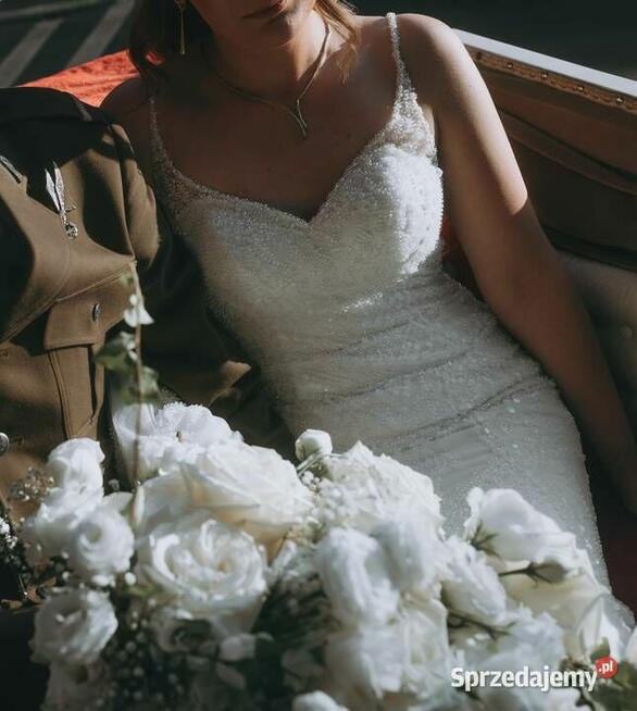 Piękna suknia ślubna z trenem, bogato zdobiona.