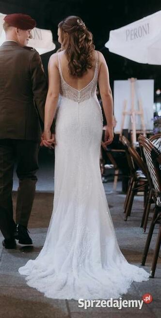 Piękna suknia ślubna z trenem, bogato zdobiona.