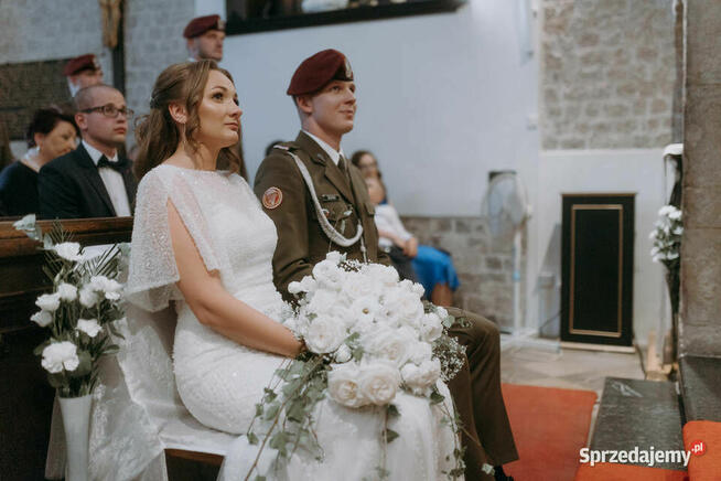 Piękna suknia ślubna z trenem, bogato zdobiona.