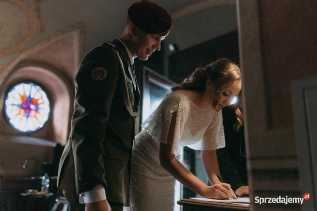 Piękna suknia ślubna z trenem, bogato zdobiona.