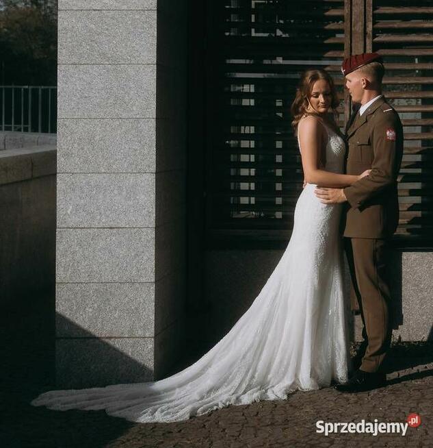 Piękna suknia ślubna z trenem, bogato zdobiona.