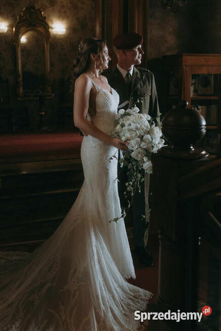 Piękna suknia ślubna z trenem, bogato zdobiona.