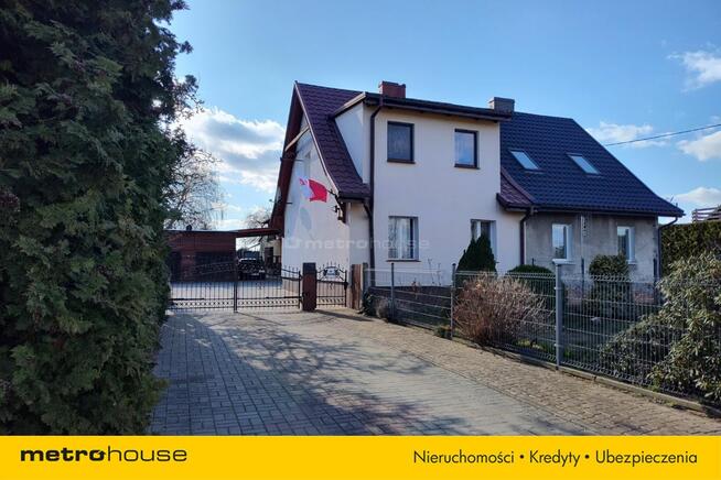 Dom w zabudowie bliźniaczej z garażami i ogrodem.