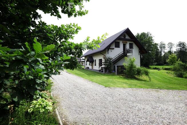 Dom ze stawem nad rzeką pośród pól i łąk