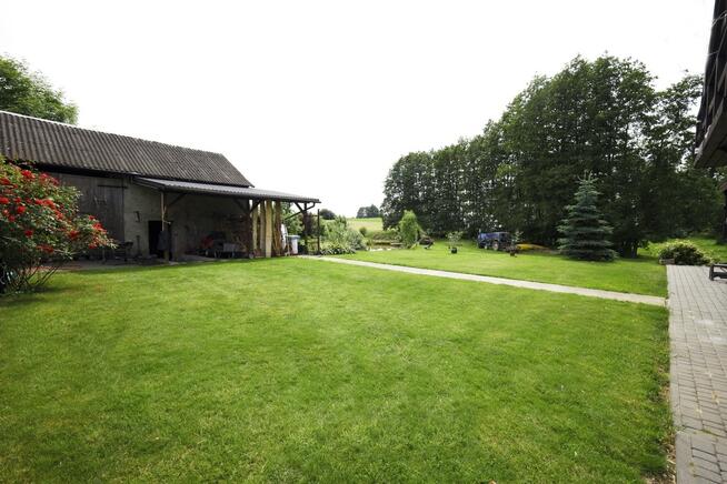 Dom ze stawem nad rzeką pośród pól i łąk