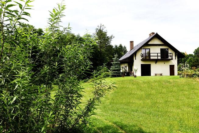 Dom ze stawem nad rzeką pośród pól i łąk