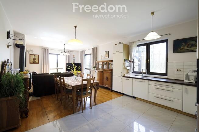 Dom ze stawem nad rzeką pośród pól i łąk