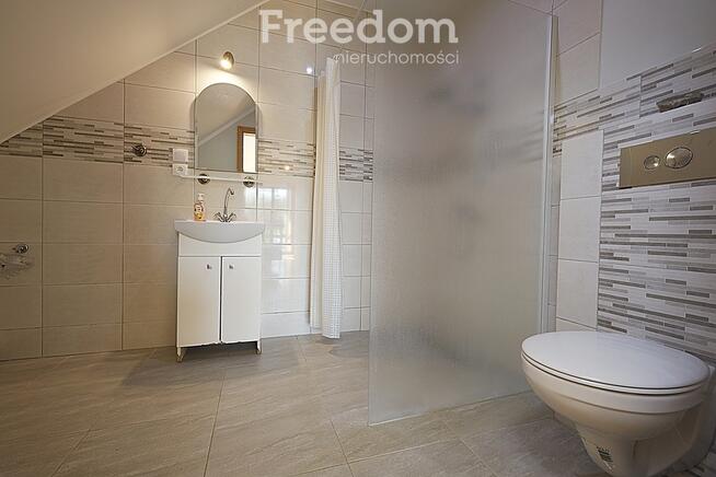 Dom ze stawem nad rzeką pośród pól i łąk