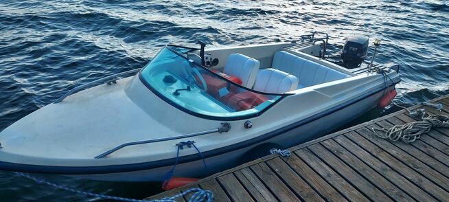 Łódź motorowa z przyczepą.