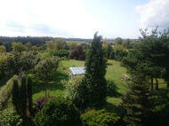 drewniany domek z kominkiem ogrodzony drewnianym płotem