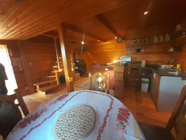 drewniany domek z kominkiem ogrodzony drewnianym płotem