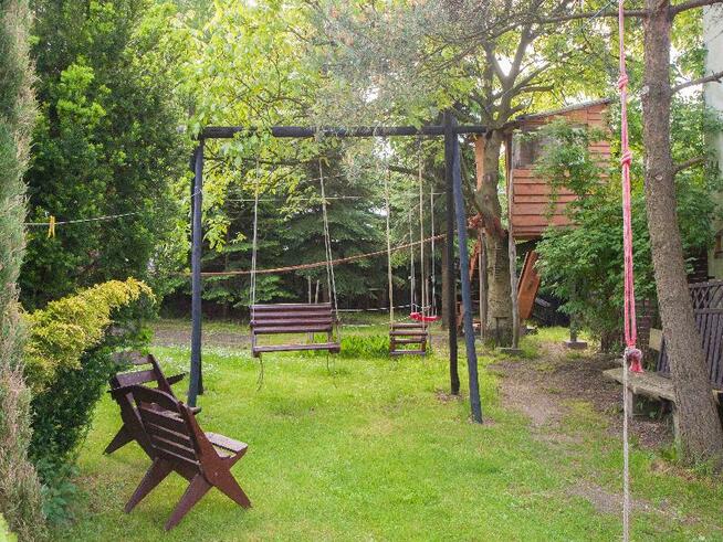 drewniany domek z kominkiem ogrodzony drewnianym płotem