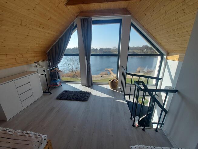 Domek z linia brzegową oraz pomostem nad jeziorem Kopiec