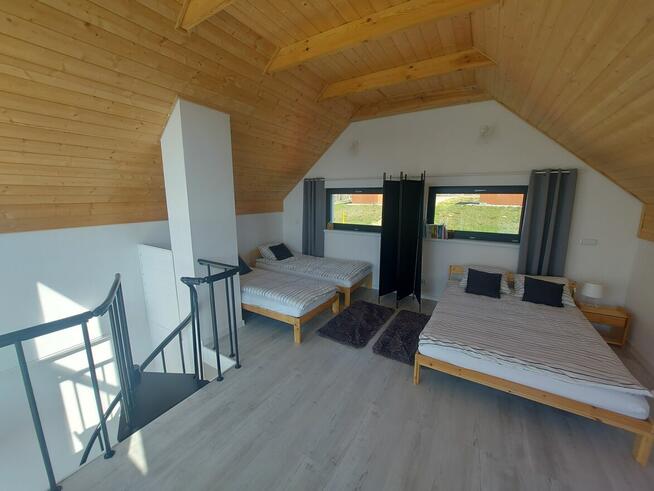 Domek z linia brzegową oraz pomostem nad jeziorem Kopiec