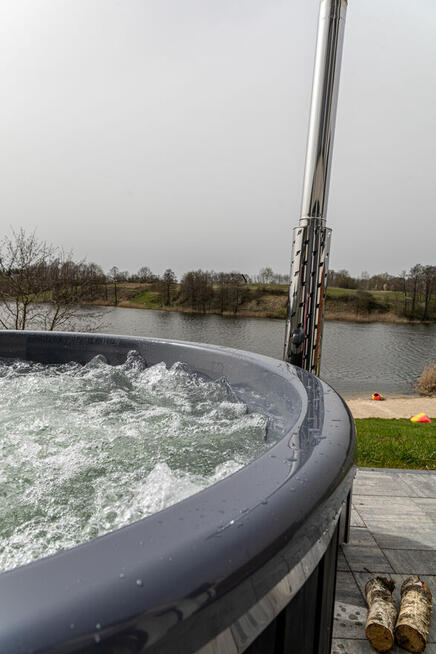 Domek z linia brzegową oraz pomostem nad jeziorem Kopiec