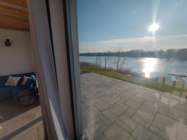 Domek z linia brzegową oraz pomostem nad jeziorem Kopiec