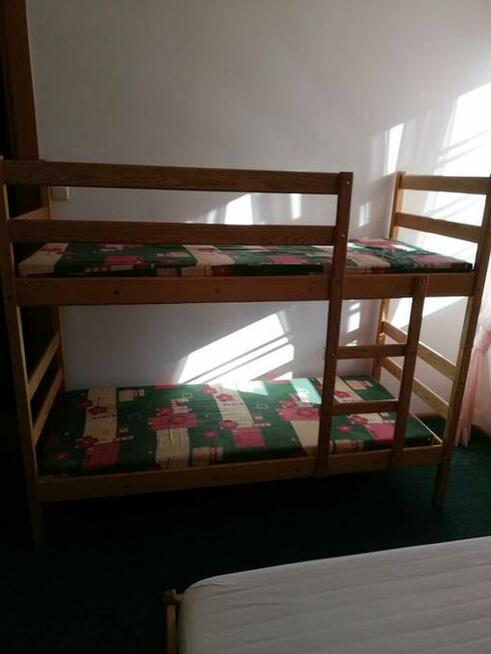 Łóżka piętrowe, stół, krzesła, żyrandol