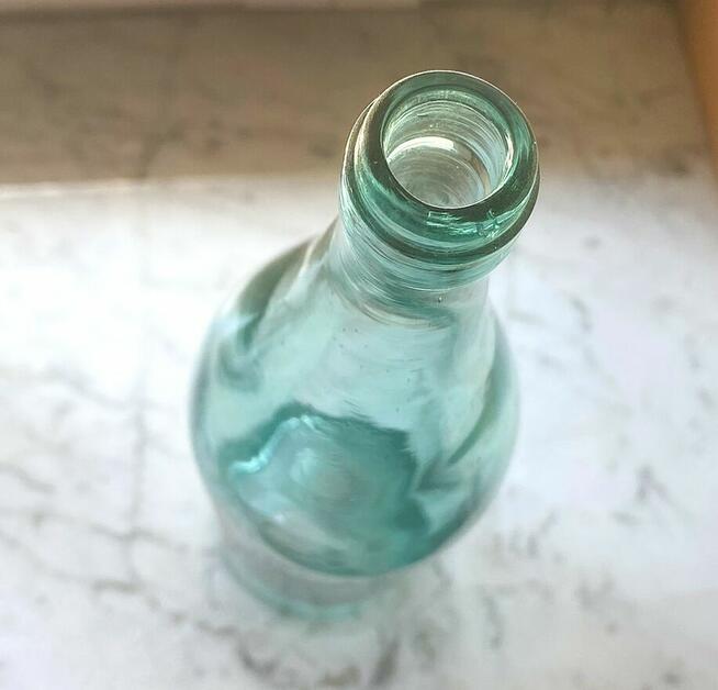 Stara przedwojenna butelka z szkła w odcieniu zieleni