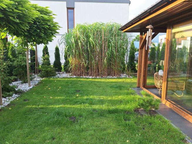 Dom szczytowy z ogrodem zimowym i garażem.