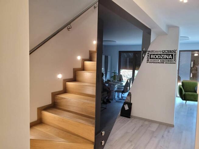 Dom szczytowy z ogrodem zimowym i garażem.