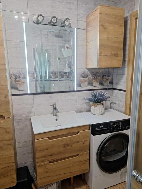 Dom szczytowy z ogrodem zimowym i garażem.