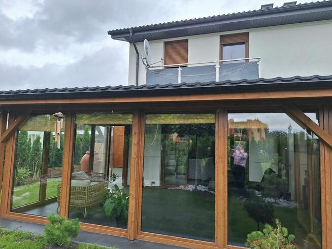 Dom szczytowy z ogrodem zimowym i garażem.