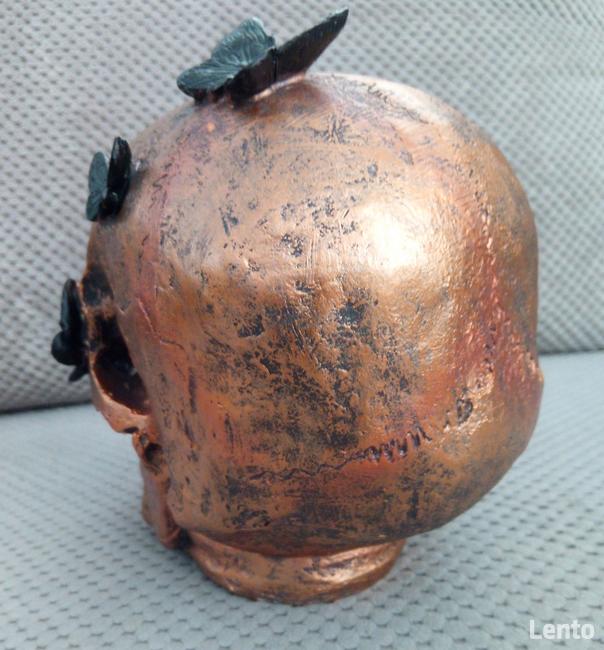 Miedziana metaliczna czaszka z czarnymi motylami