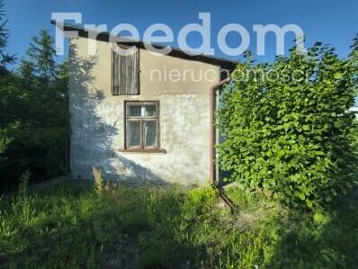 Mały dom z budynkiem gospodarczym.